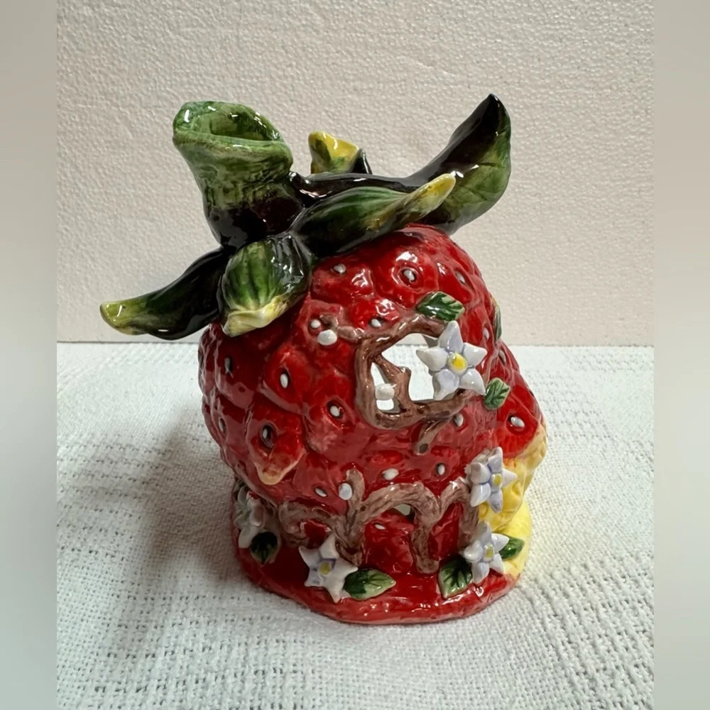 This is a vintage ceramic strawberry candle or tealight holder,